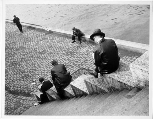 Tres hombres sentados en las escaleras junto al Sena