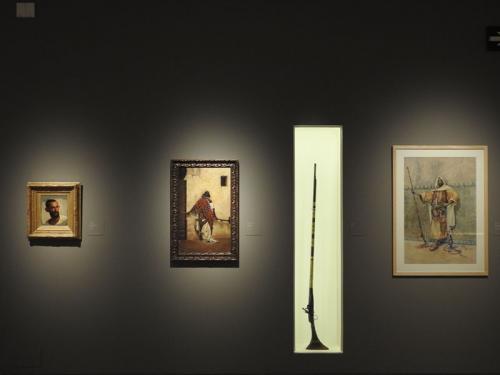 Detalle de la exposición con obras de Isidore Pils, Rafael Senet y Vicenç Miquel Pous, junto a la espingarda (1859-1860) del Museu de Reus